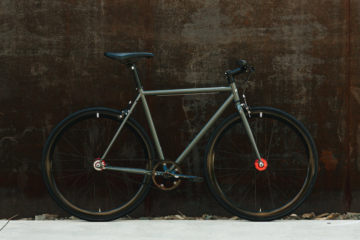 State Bicycle Co. Core-Line Earthstone against a wall, lifestyle shot