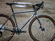 Wilde Rambler SL Charcoal Disco gravel frameset with Wayfinder carbon fork, side view on gravel