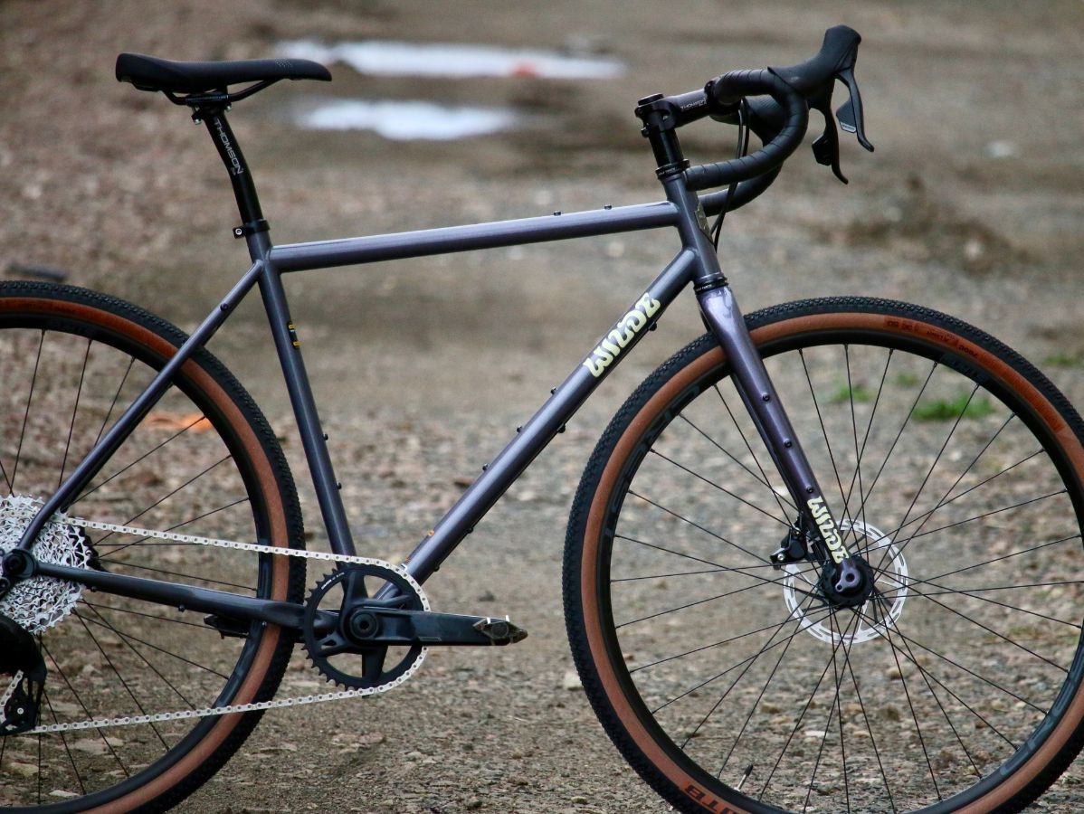 Wilde Rambler SL Charcoal Disco gravel frameset with Wayfinder carbon fork, side view on gravel